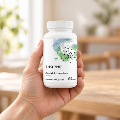 Thorne Acetyl-L-Carnitine 500 mg held in an adult hand to show its size